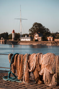 Fishing net at harbor against clear sky during sunset