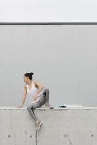 Woman sitting on retaining wall