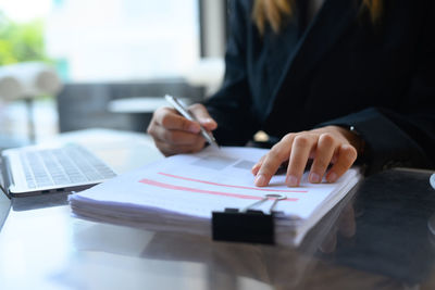 Midsection of business colleagues working on table