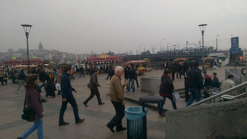 People on street in city against sky