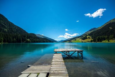 Pier over lake against blue sky