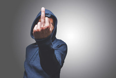 Mid adult man gesturing while standing against gray background