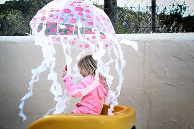 Rear view of girl playing with umbrella