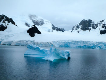 Sea and iceberg against glacier and mountain in antarctica
