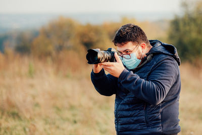 Man photographing on field