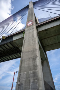 Low angle view of bridge against cloudy sky