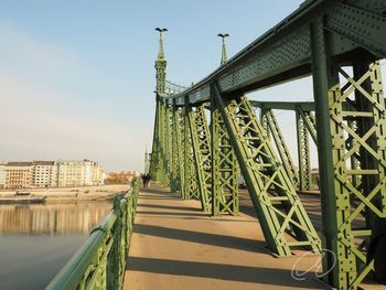 Bridge over river against cloudy sky