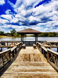 Pier on lake against cloudy sky