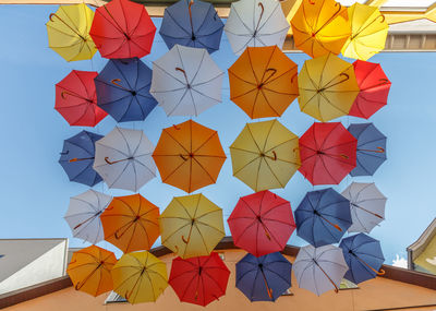 Low angle view of multi colored umbrellas against sky