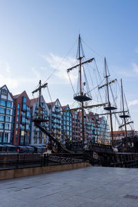 Sailboats moored in city against sky