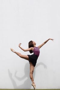 Full length of woman dancing against white background
