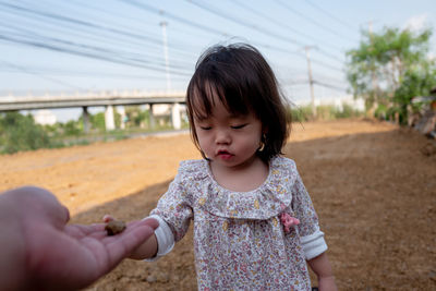 Cropped hand giving rock to girl