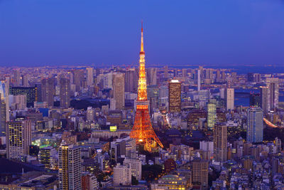 Illuminated buildings in city against sky