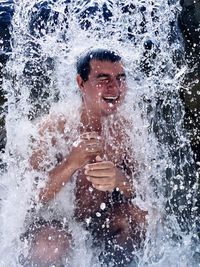 Happy man enjoying in waterfall