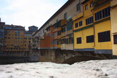 Residential buildings by street against sky in city