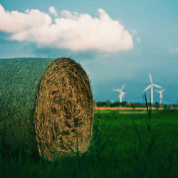 Hay bales on field against sky