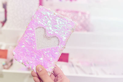 Close-up of hand holding pink heart shape