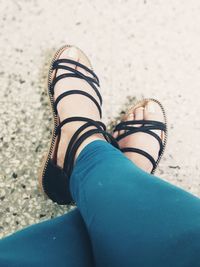 Low section of woman wearing sandals on footpath