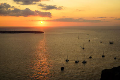 Scenic view of boats in sea against sky at sunset