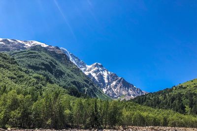 Scenic view of mountains against blue sky