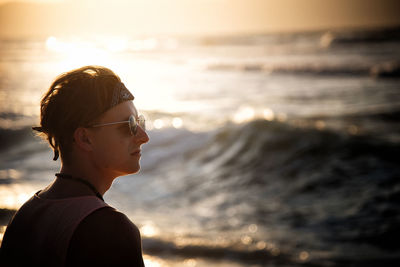 Portrait of man on beach against sky during sunset