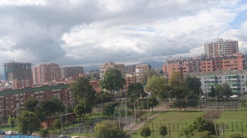 Buildings in city against cloudy sky