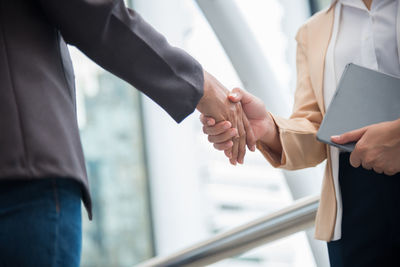 Midsection of business people shaking hands