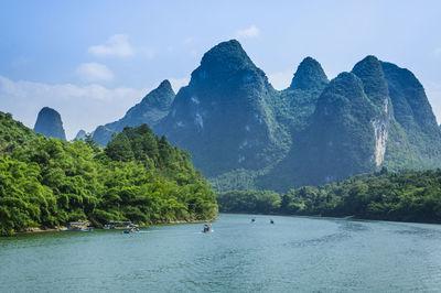 Scenic view of sea and mountains against sky