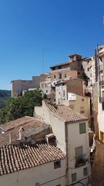 Houses in town against clear blue sky