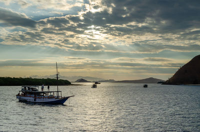 Sailboats in sea against sky during sunset