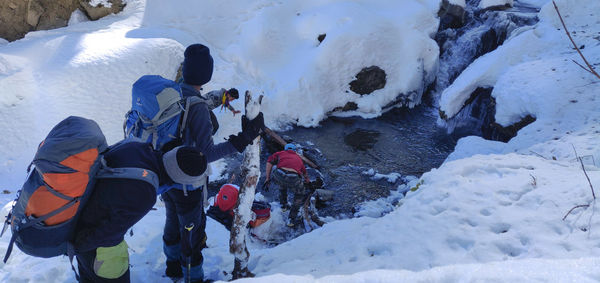 Rear view of people on snow covered landscape during winter