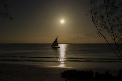 Silhouette sailboat in sea against sky during sunset