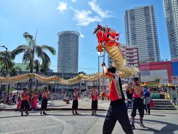 People at town square with city in background