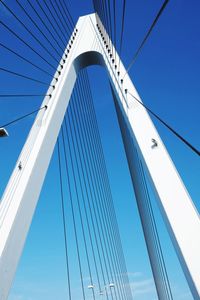 Low angle view of suspension bridge against clear blue sky