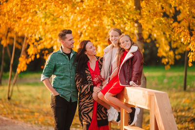 Rear view of people walking on autumn leaves