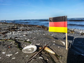 Close-up of flag on beach against sky