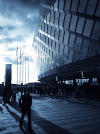 People walking in city against sky