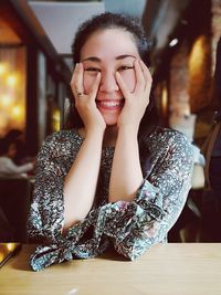 Portrait of a smiling young woman sitting on table