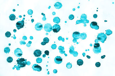 Close-up of blue water drops on white background