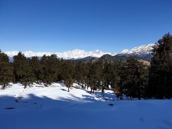 Scenic view of snowcapped mountains against blue sky
