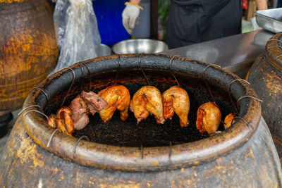 Outdoor restaurant kitchen preparing grilled pork and chicken in a barbecue jar