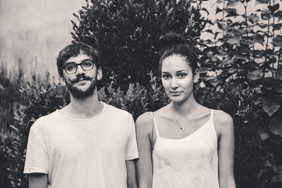 Portrait of couple standing against trees