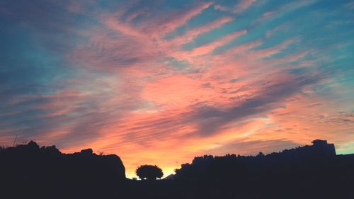 Silhouette of trees against dramatic sky