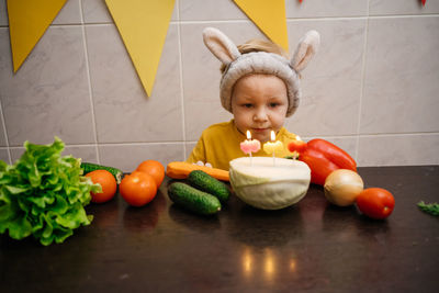 Vegetarian cake with candles birthday vegetables baby in rabbit ears copy space. high quality photo