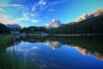 Reflection of rocky mountains in lake against blue sky