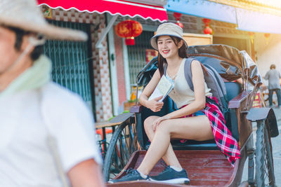 Portrait of smiling young woman sitting outdoors