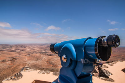 Close-up of coin-operated binoculars against cloudy sky