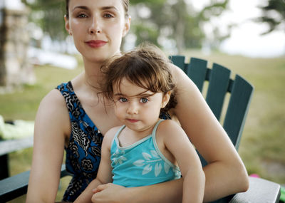 Portrait of mother and daughter sitting on chair