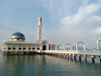 View of building by water against sky