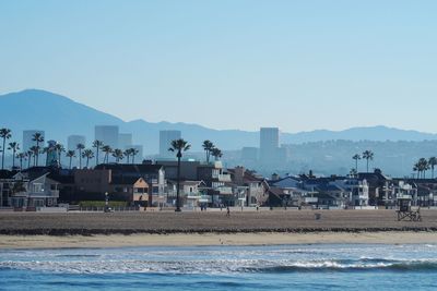 Houses by sea against clear sky